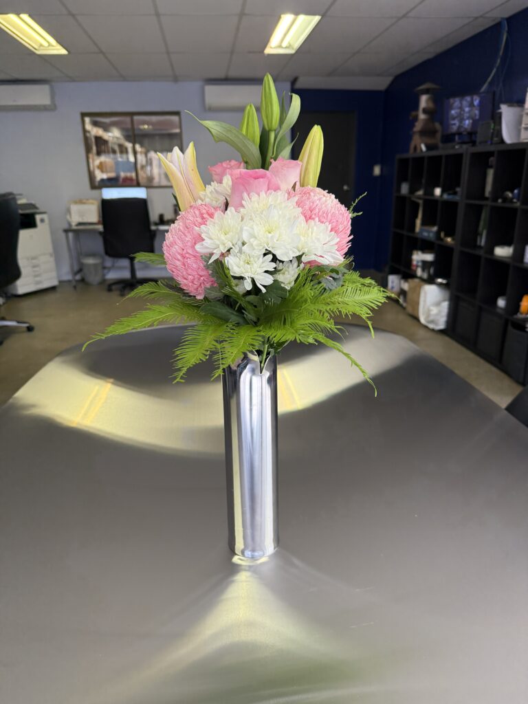 Stainless steel flower vase with a brushed finish on a flat surface