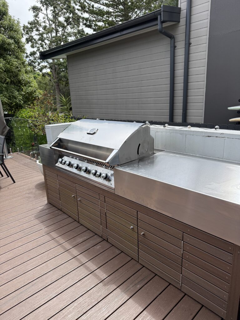 Stainless steel outdoor BBQ area with custom benchtops and integrated appliances